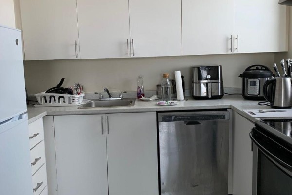 Kitchen with white cabinets, stainless steel appliances including a dishwasher, and light countertops. - 1010 - 1440 Heron Road, Ottawa
