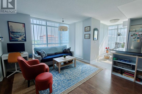 Living room with blue couch, orange armchair, coffee table, and blue patterned rug. - 1010 - 205 Sherway Gardens Road, Toronto