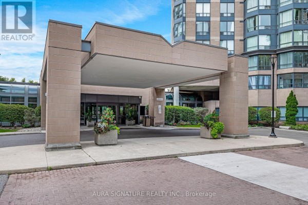 Close-up of the entrance canopy and building facade with decorative planters. - 1010 - 3 Hickory Tree Road, Toronto