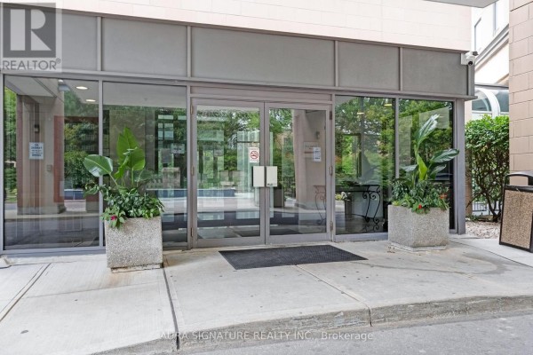 Glass entrance doors with metal frames, flanked by large planters and concrete pathway. - 1010 - 3 Hickory Tree Road, Toronto
