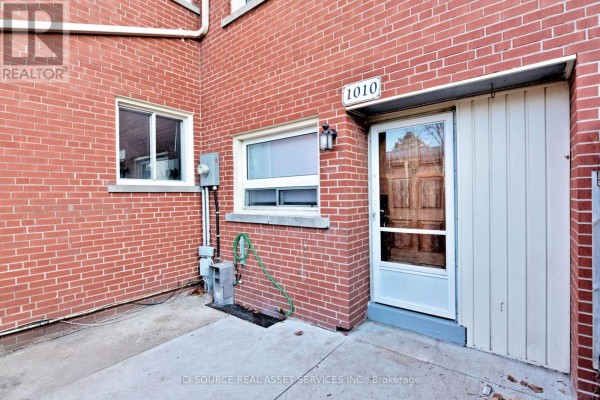 Close-up of the front door and windows of townhouse unit 1010 with red brick exterior. - 1010 Kipps Lane, London East