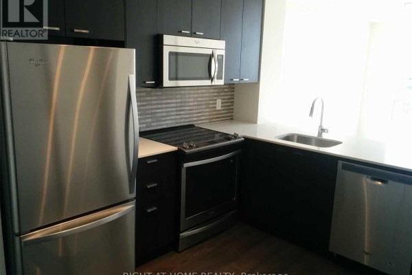 Modern kitchen with stainless steel appliances, dark cabinets, white countertops, and tiled backsplash. - 1011 - 30 Roehampton Avenue, Toronto