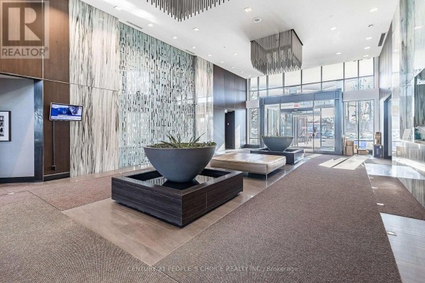 Spacious lobby with water features, seating, modern light fixtures, and floor-to-ceiling windows. - 1012 - 205 Sherway Garden, Toronto