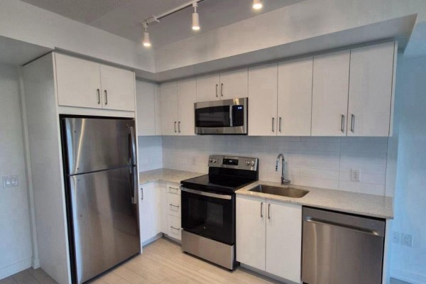 Kitchen with stainless steel refrigerator, microwave, stove, dishwasher, white cabinets, and granite countertops. - 1014 - 4010 Eglinton Avenue W, Toronto