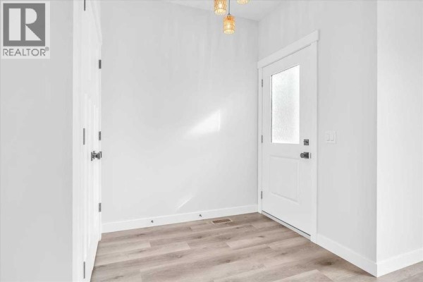Side view of duplex showing windows and pathway - 1014 Limit Avenue, Crossfield
