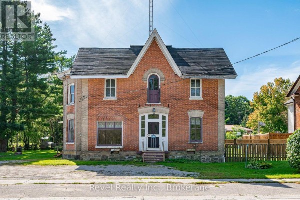 Red brick two-storey house with white trim and a large front door. - 1014 Portage Road, Kawartha Lakes