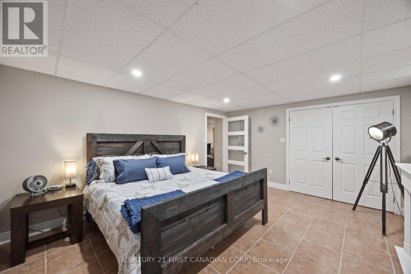 King size bed with blue bedding and wooden headboard - 10159 Meadowlilly Crescent Lambton Shores