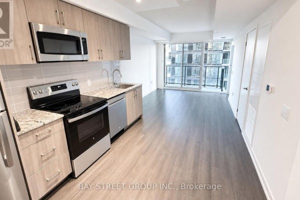 Open concept living area and kitchen with a balcony overlooking the city. - 1016 - 4010 Eglinton Avenue W, Toronto