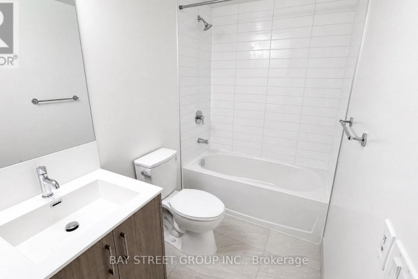 Clean bathroom with a white tiled shower/tub, toilet, and a modern vanity with sink. - 1016 - 4010 Eglinton Avenue W, Toronto