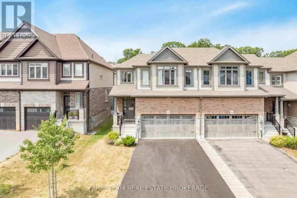 Front view of townhouses with brick and siding exteriors, manicured lawns and asphalt driveways. - 1016 Wright Drive, Midland
