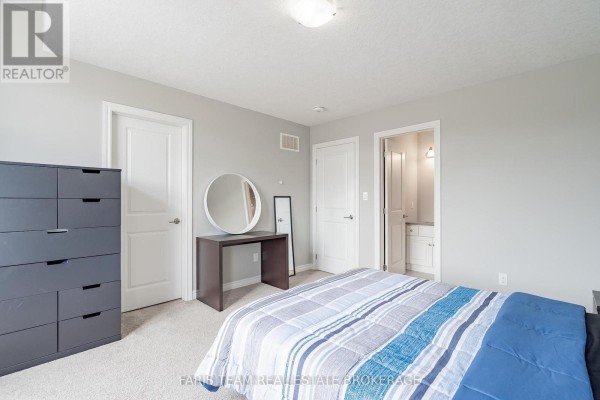 Bedroom with dresser, vanity, round mirror, and ensuite entrance - 1016 Wright Drive Midland