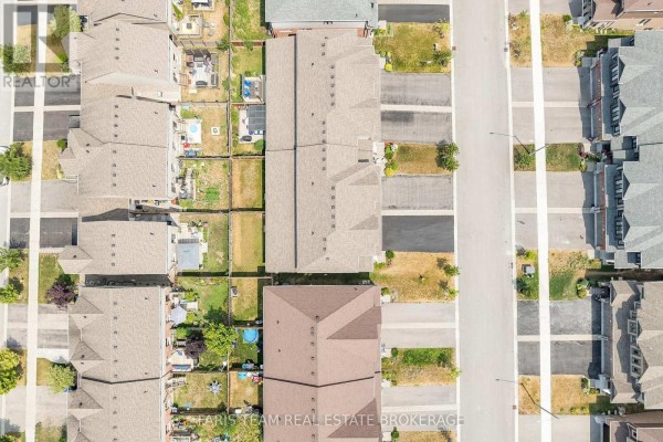 Aerial view of townhouses with driveways and backyards - 1016 Wright Drive Midland