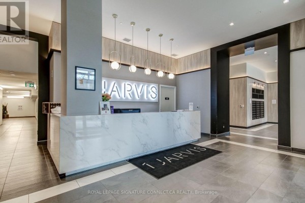 Building lobby with a marble reception desk, modern light fixtures, and mailboxes. - 1017 - 1 Jarvis Street, Hamilton