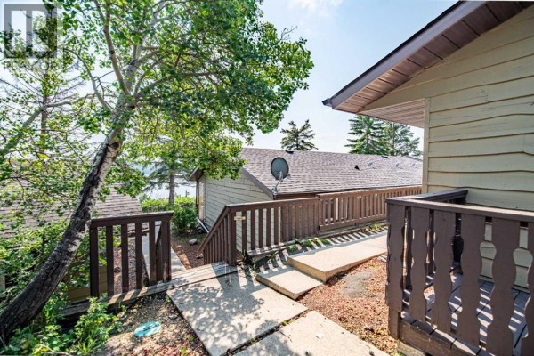 Exterior walkway with steps and railings leading past resort units towards the lake. - 1018, 25054 South Pine Lake Road, Rural Red Deer County