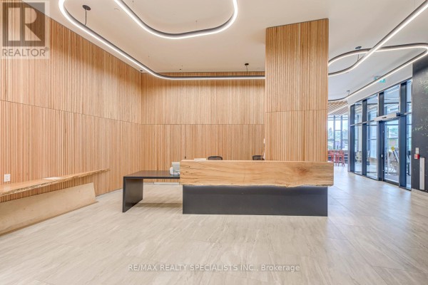 Building reception desk with a large wooden slab and slatted wood walls. - 1018 - 2485 Eglinton Avenue, Mississauga