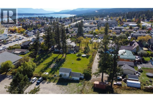 Aerial view of residential neighborhood with lake and mountains in the distance. - 1018 5th Street, Invermere