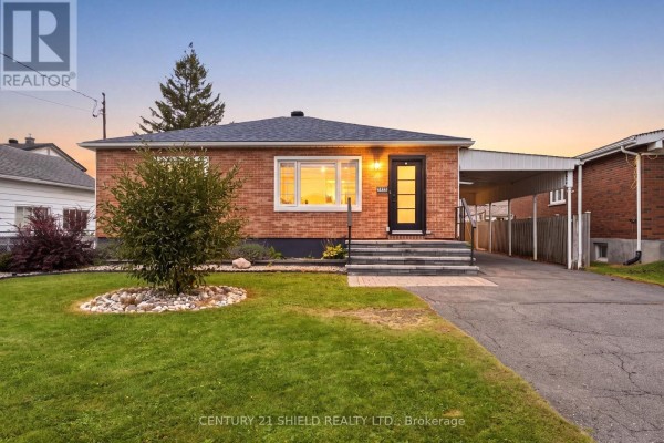 Front exterior of a brick bungalow with a covered carport and a paved driveway. - 1019 Miron Avenue, Cornwall