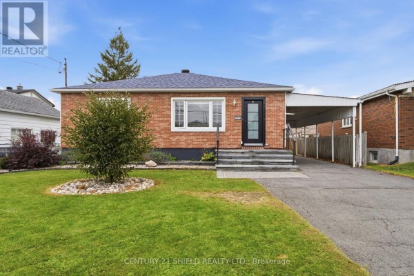 Front exterior of a brick bungalow with a covered carport and a paved driveway. - 1019 Miron Avenue, Cornwall
