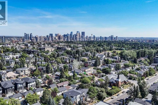 Aerial view of a city skyline and residential neighborhood with a blue sky. - 102, 1811 34 Avenue Sw, Calgary
