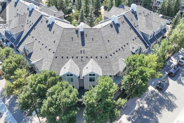 Aerial view of the roof and upper floors of an apartment building surrounded by trees. - 102, 1811 34 Avenue Sw, Calgary