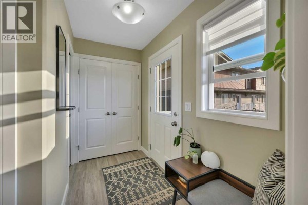 Modern kitchen with dark brown cabinets, stainless steel appliances, and a white quartz countertop island. - 102, 6300 58a Street, Rocky Mountain House
