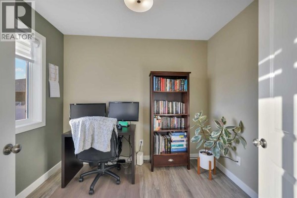 Entrance hallway with double white closet doors, a window, and a small bench with storage. - 102, 6300 58a Street, Rocky Mountain House