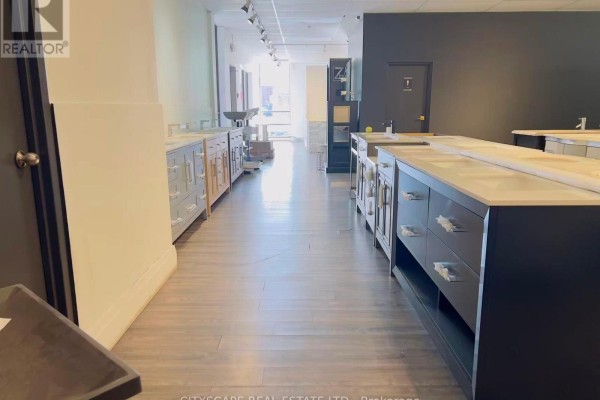 Hallway view of a showroom displaying bathroom vanities and sinks. - 102 - 100 Steelcase Road E, Markham