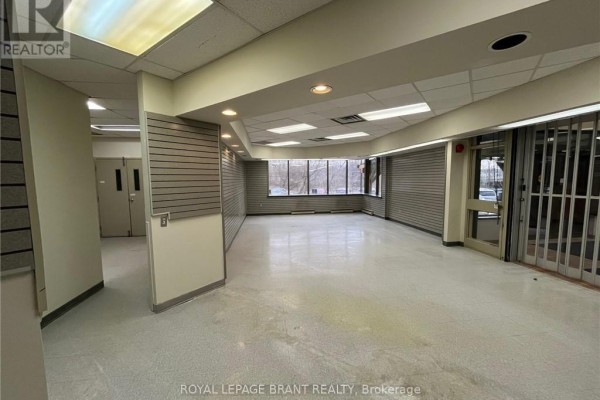 Wide view of an empty commercial interior showing multiple rooms and large windows. - 102 - 139 Grand River Street N, Brant
