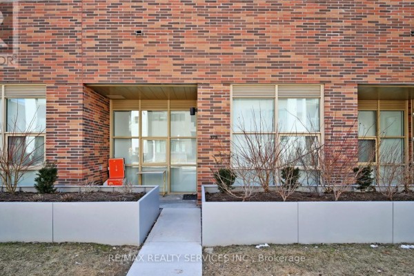 Ground floor apartment entrance with glass doors, planters, and brick exterior. - 102 - 1787 St. Clair Avenue W, Toronto