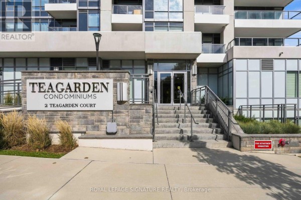 Close-up of the Teagarden Condominiums entrance with stone accents and stairs leading to glass doors. - 102 - 2 Teagarden Court N, Toronto