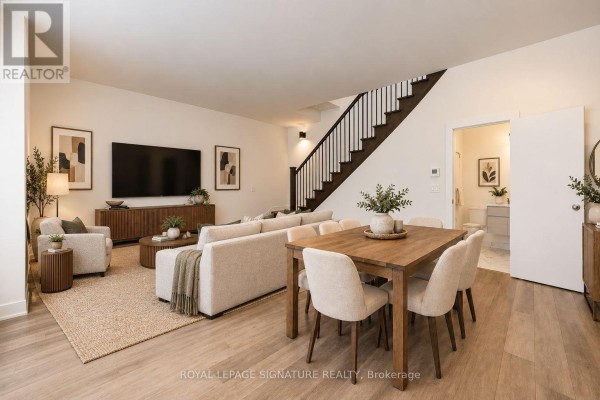 Living and dining area with beige sectional sofa, wood dining table and chairs, and wood-look flooring. - 102 - 2 Teagarden Court N, Toronto