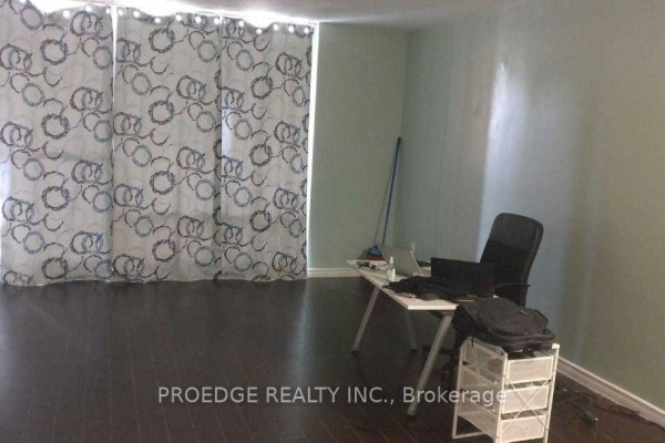 Apartment entrance with a tiled floor, white door, mirrored closet doors, and a brick accent wall. - 102 - 5 Massey Square, Toronto