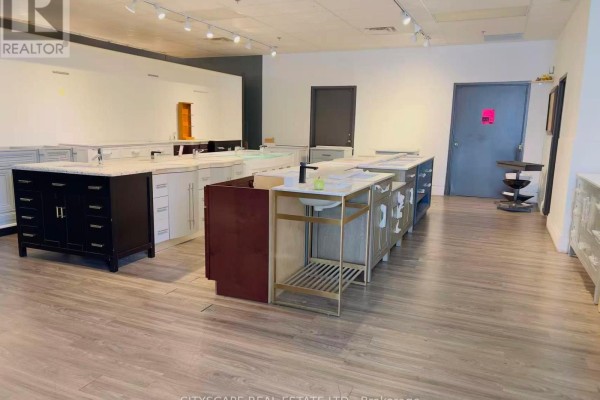 Wide view of a showroom with numerous bathroom vanity displays and a dark gray wall. - 102 - Opt D - 100 Steelcase Road E, Markham