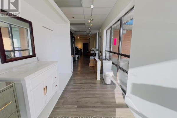 Interior view of a showroom with white vanity on the left and toilets displayed to the right. - 102 - Opt D - 100 Steelcase Road E, Markham