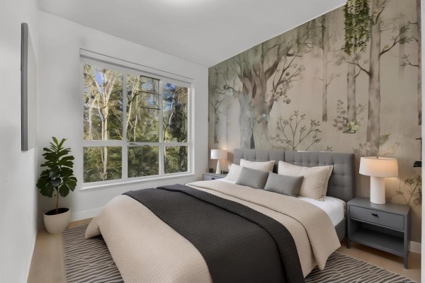 Cozy bedroom featuring a tufted headboard, neutral bedding, and a window with a view of trees. - 102 3480 146a Street, Surrey