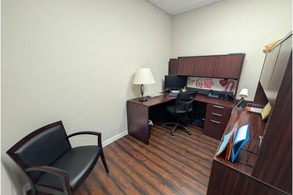 Corner office with a dark wood desk, computer, leather chair, and a side desk. - 102 5668 192 Street, Surrey
