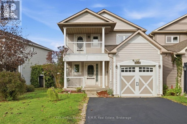 A beige-sided house with a white-trimmed garage door and a two-story covered front porch. - 102 Boswell Drive, Clarington