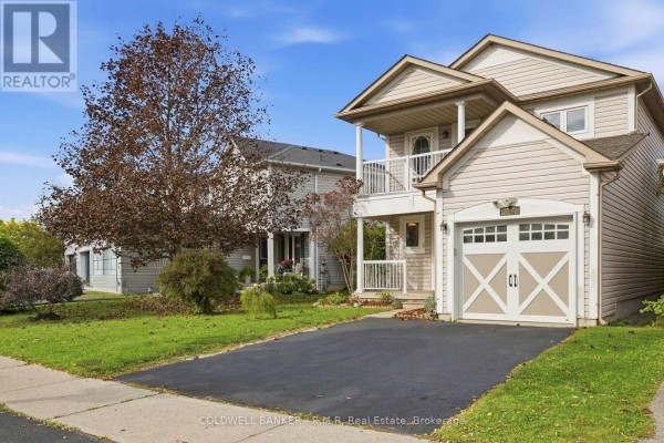 Side exterior view of a beige house with a garage, asphalt driveway, and mature trees. - 102 Boswell Drive, Clarington