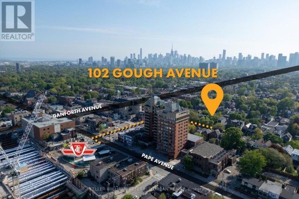 Modern white kitchen with stainless steel appliances, quartz countertops, and dark hardwood floors. - 102 Gough Avenue, Toronto