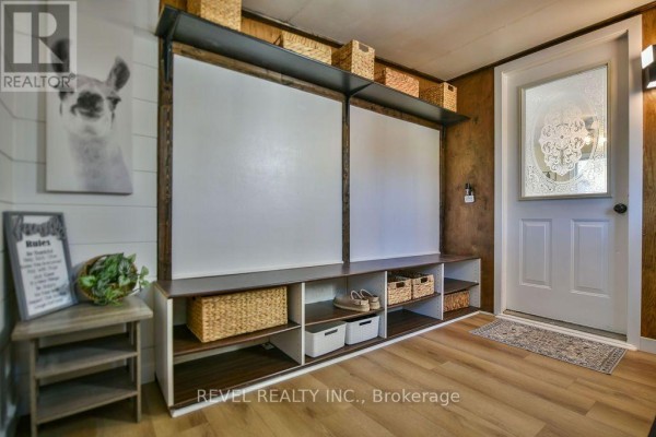 Interior mudroom with large storage unit, white paneling, and llama artwork. - 102 Notre Dame Place, Timmins