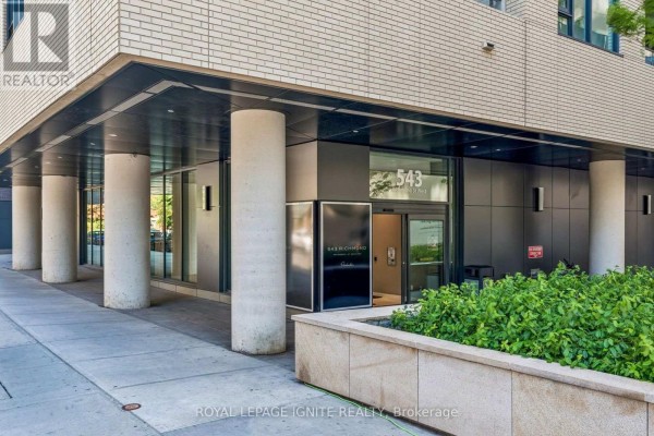Entrance to apartment building 543 with large concrete pillars and modern signage. - 1021 - 543 Richmond Street W, Toronto