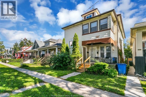Street view of a duplex with green lawns, sidewalk, and neighboring houses on a sunny day. - 1022-1024 Lincoln Rd, Windsor