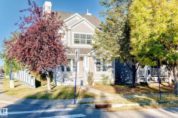 Front view of the house with fall foliage and a sidewalk leading to the entrance. - 1022 80 St Sw, Edmonton