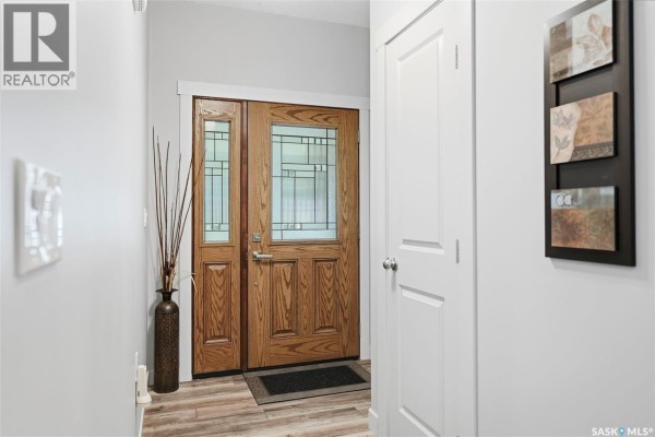 Interior view of a home entrance with double wooden doors, gray walls, and wood-look flooring. - 1022 Rooster Road, Turtle Lake