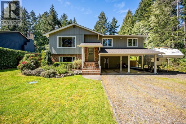 Exterior of the house showing the main entrance with brick steps and windows. - 1023 Sylvan Rd, Comox