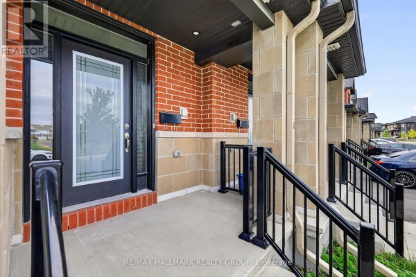 Close-up of townhouse front entrance with glass-paneled door and brick facade. - 1024 Montelena Road, Ottawa
