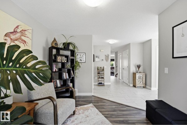 View from the living room into a hallway with tiled floors and doorways. - 10245 152 St Nw, Edmonton