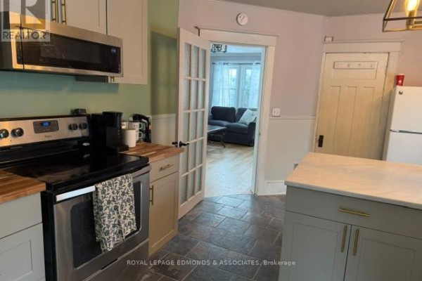 Kitchen featuring stainless steel appliances, light cabinetry, and a breakfast bar. - 1028 Pembroke Street E, Pembroke