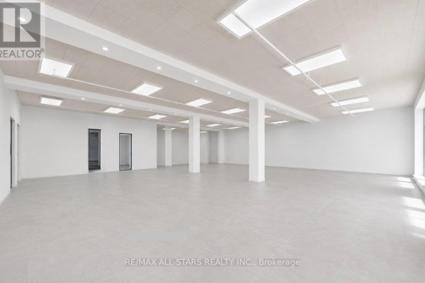 Spacious commercial interior with white walls, column supports, and overhead lighting. - 103 - 14 Mccaul Street, Toronto