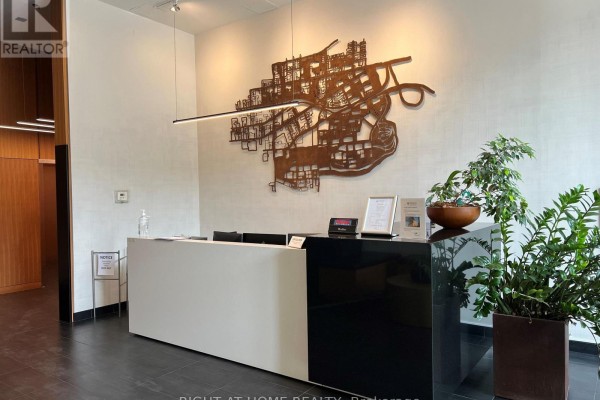 Building lobby with a black and white reception desk and city map artwork. - 103 - 510 King Street E, Toronto